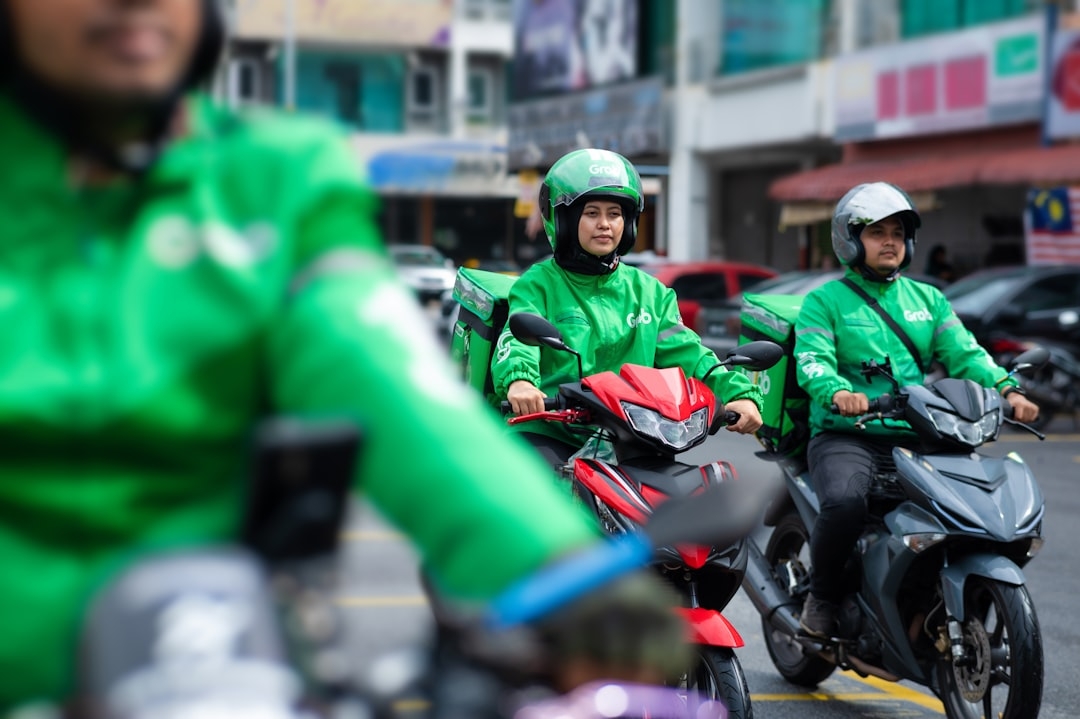 a couple of men riding motorcycles down a street