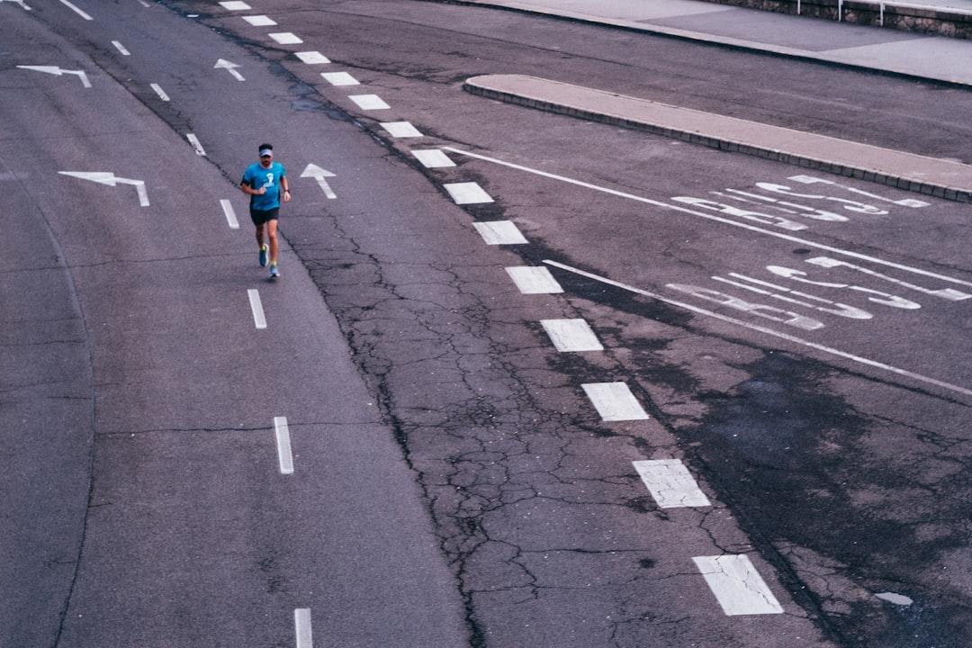 woman in red jacket walking on pedestrian lane during daytime